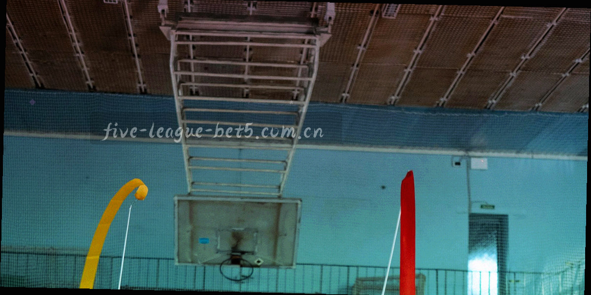 空荡看台与跑道线条构成的低角度抽象构图，冷色灯光下只有结构没有人群